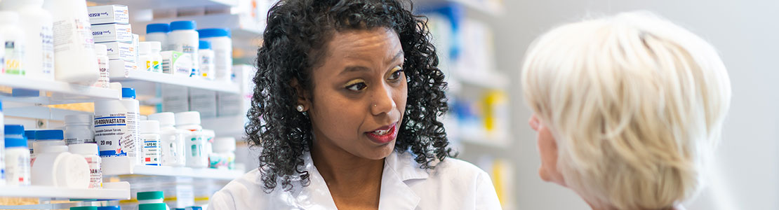 Female pharmacist talking with lady